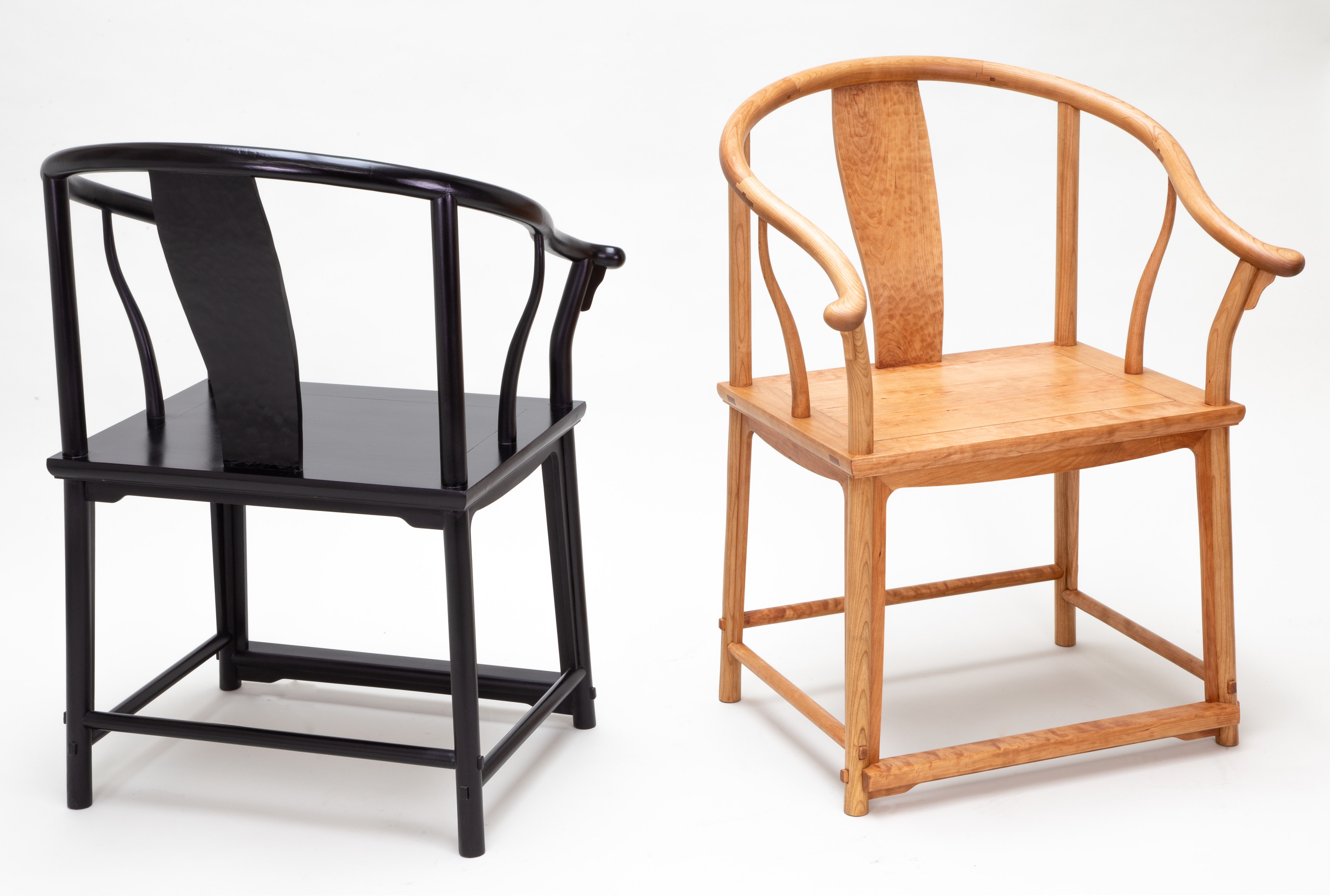 Two wooden chairs next to each other, black and wood