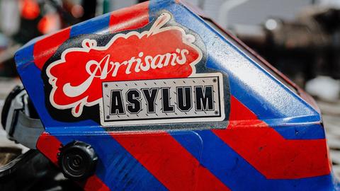 Artisans Asylum logo emblazoned on a welding helmet.