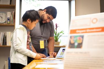 Mentor and mentee read together at a table