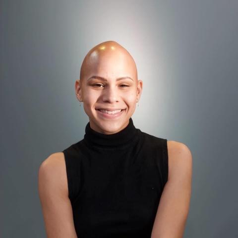 woman poses for picture with gray background