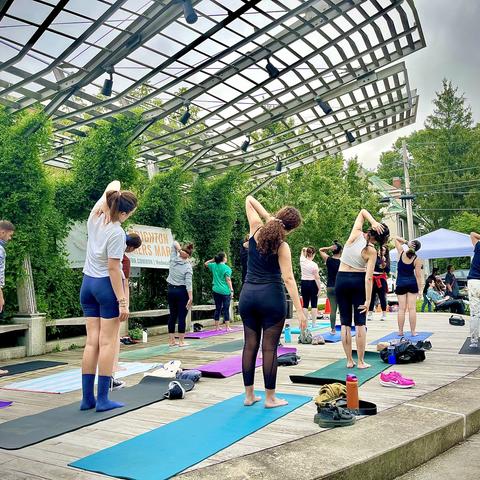 people stretching on yoga mats in outdoor plaza