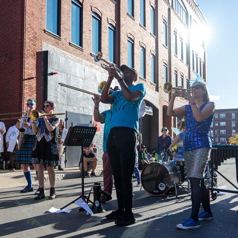 Group of band members playing brass instruments in the streets