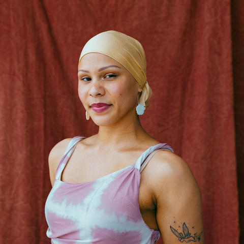 woman wearing purple poses with red background