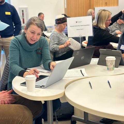 people at roundtables with laptop 