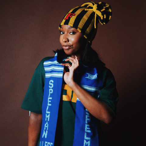 woman stands proudly holding spellman scarf 