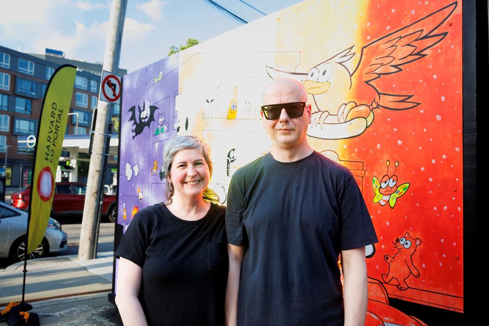 Outdoors Photo of Jennifer and Ansis, Artists of the Mural Behind them