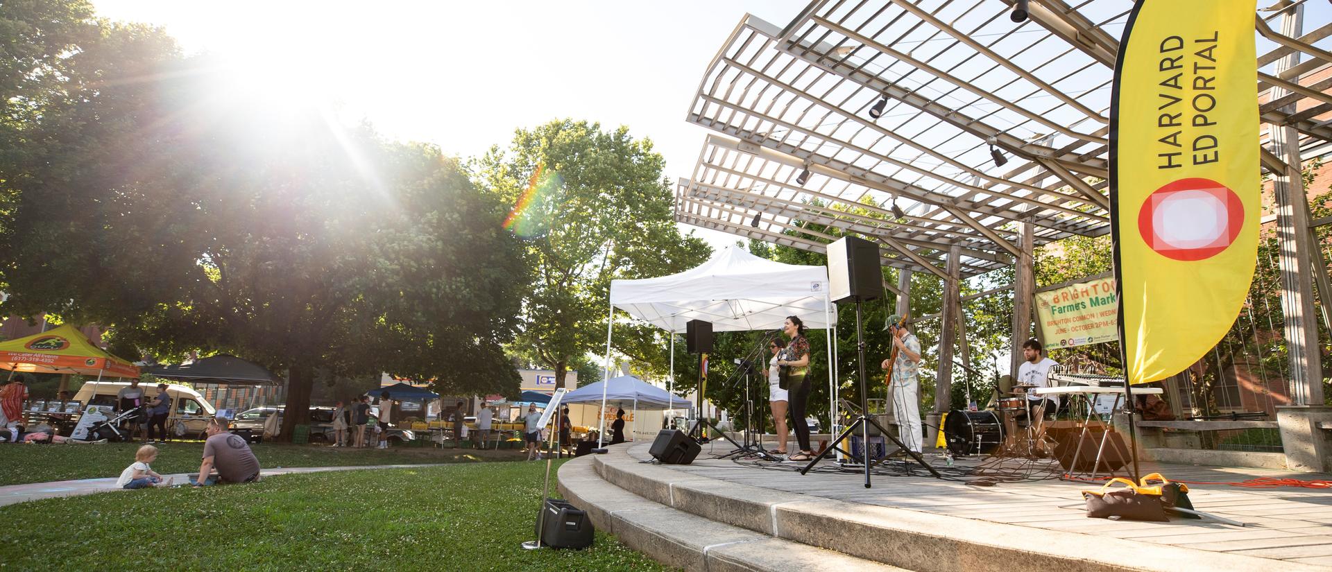 concrete stage and grassy area with dad and son listening to band
